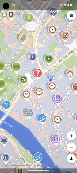 Screenshot of StreetComplete: a street map covered with colorful quest pins — clocks, checkboxes, a red question mark, stair and wheelchair icons, a bench, bike parking — each marking a bit of missing data ready to be filled in.